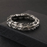 Silver bracelet with intricate design on a black fabric background