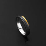 Ring with black and gold design on a dark background