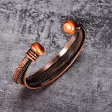 Copper bracelet with textured design on a gray background