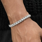 Silver bracelet with diamonds on a wrist against a black textured background